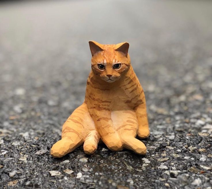 a small toy cat sitting on the ground