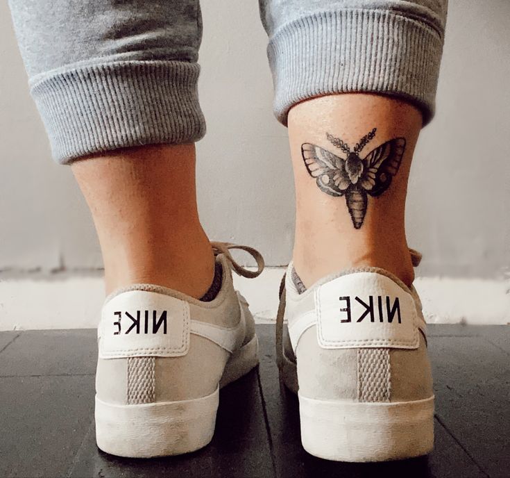 two people with tattoos on their feet and one has a butterfly tattoo on the ankle