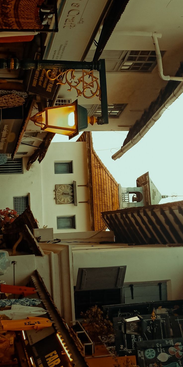 a room filled with lots of clutter next to a ceiling lamp and clock on the wall