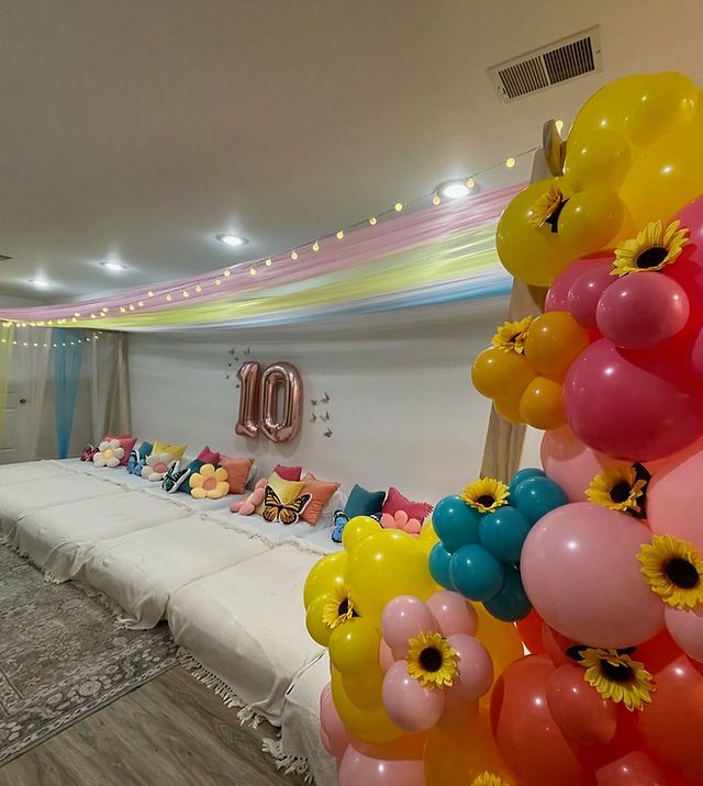 a room with balloons and stuffed animals on the bed in front of it is decorated for an 80th birthday party