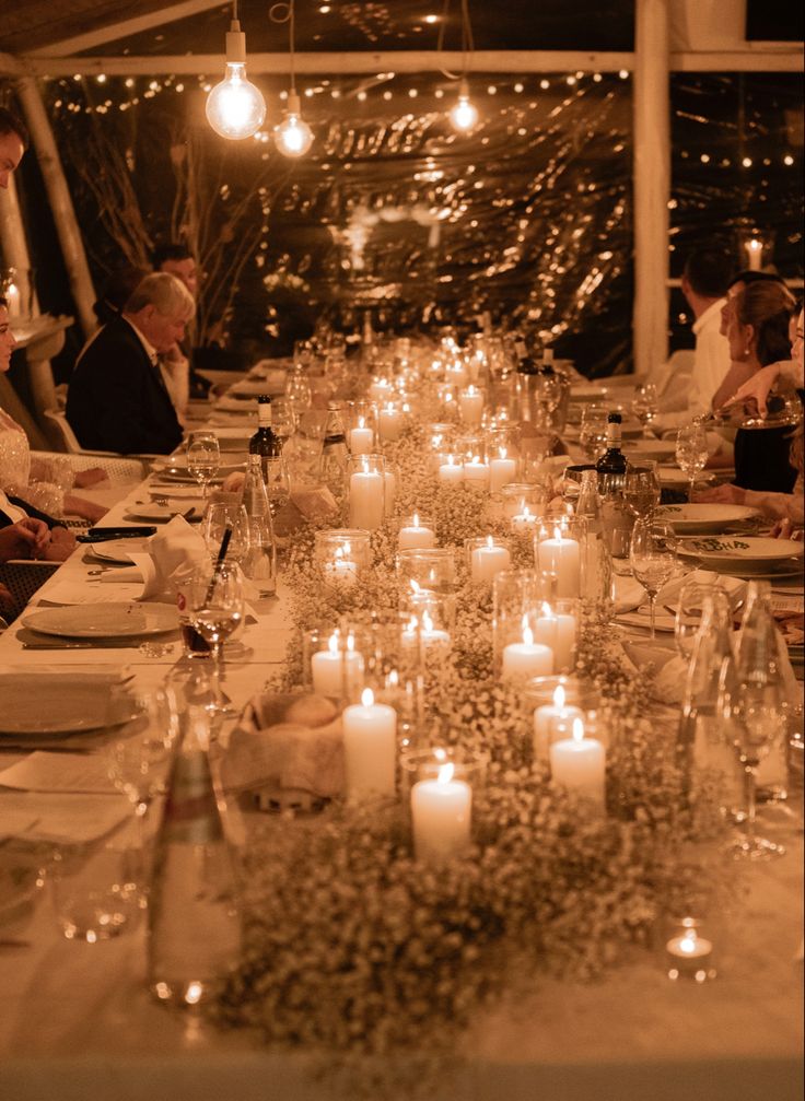 a long table is set with candles and plates