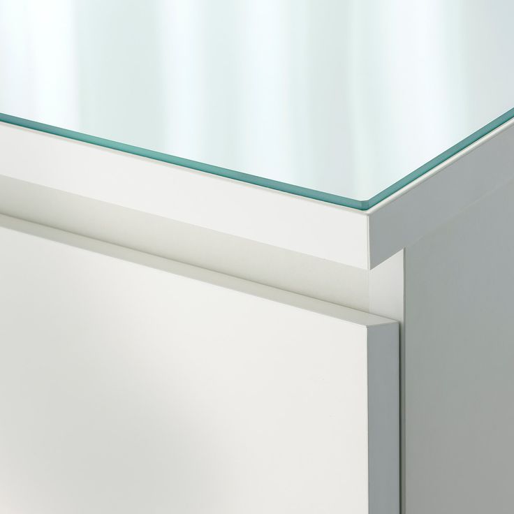 a white cabinet with a glass top on it