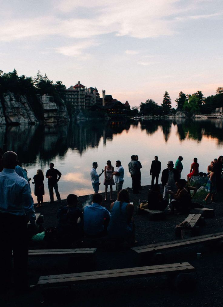 a group of people standing next to a body of water