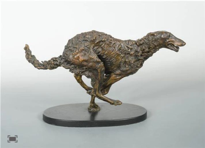 a bronze sculpture of a dog running on its hind legs