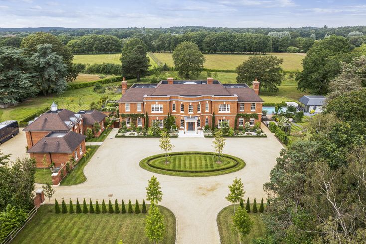 an aerial view of a large brick mansion surrounded by trees