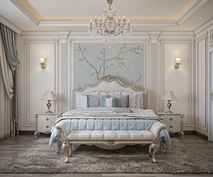 a large white bed sitting in a bedroom next to a chandelier