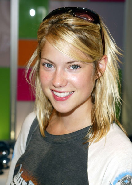 a young blonde woman with sunglasses on her head