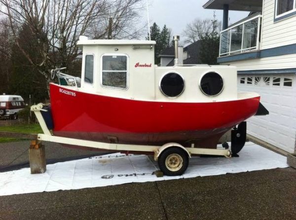 a red and white boat sitting on top of a trailer