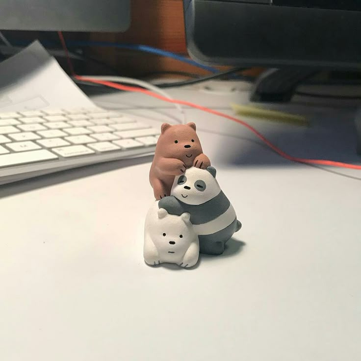 two small figurines sitting next to each other on a desk