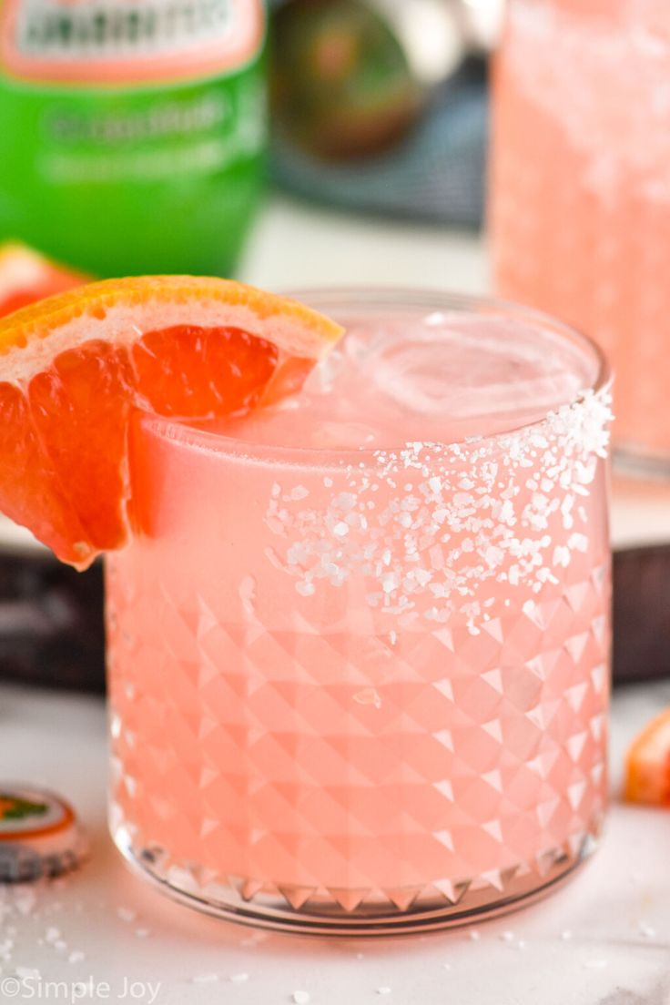 a pink drink with an orange slice on the rim