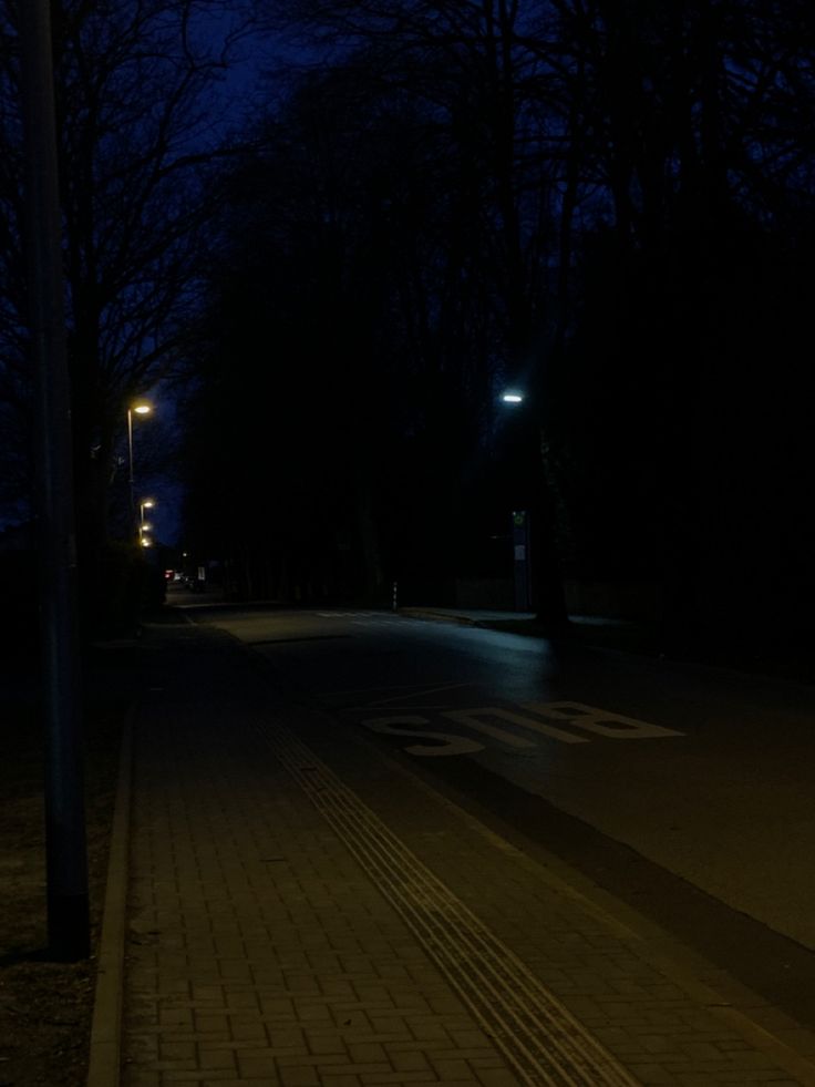 an empty street at night with no one on it or people walking down the sidewalk