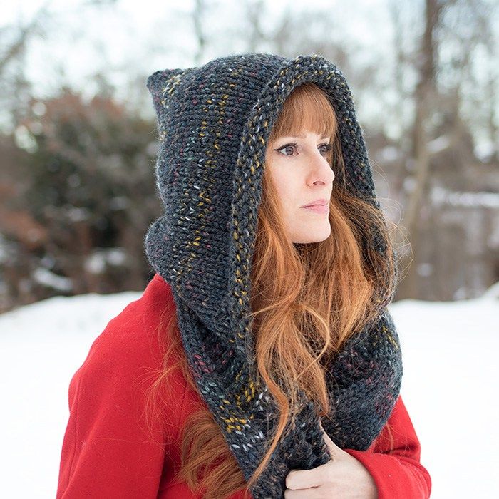 a woman with red hair wearing a knitted hat and scarf