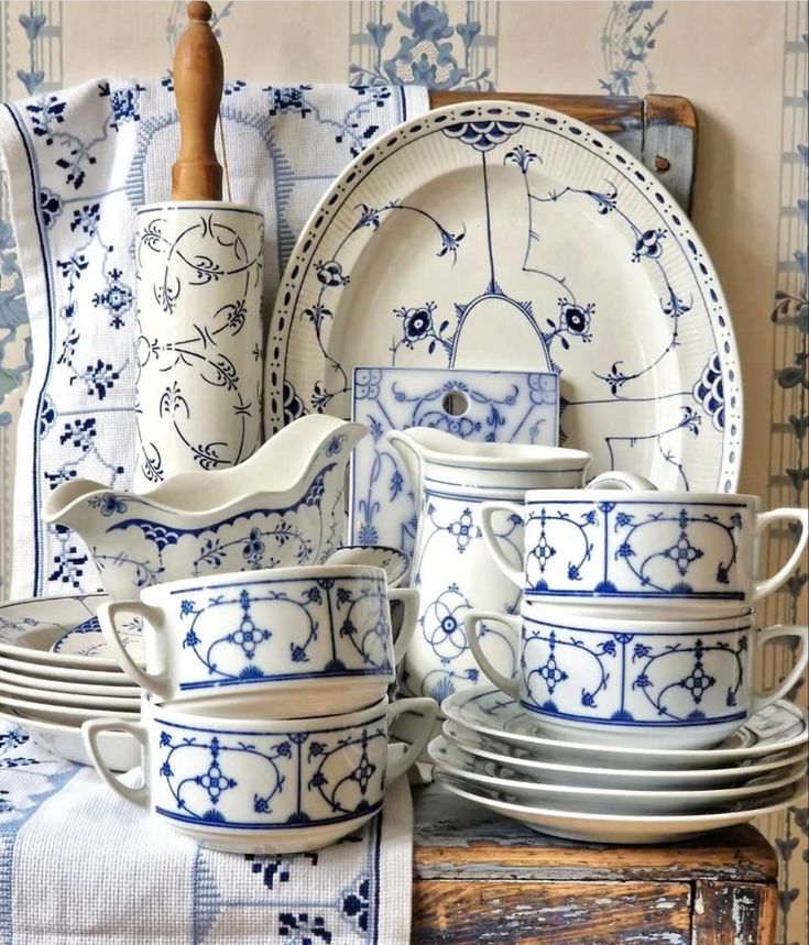 blue and white dishes are stacked next to each other on a wooden tablecloth rack