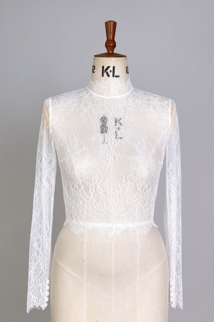 a mannequin wearing a white lace top