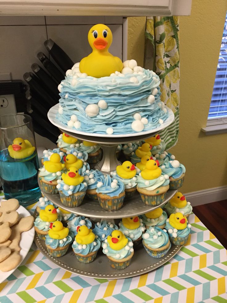 a three tiered cake with cupcakes and rubber ducky decorations on it