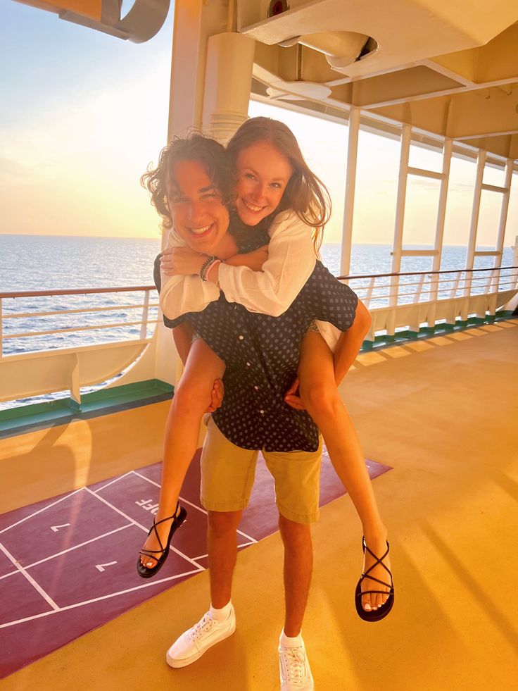 two girls hugging each other on the deck of a cruise ship, with the ocean in the background