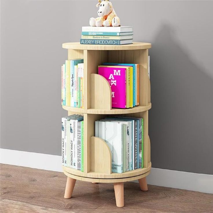 a book shelf with books and a teddy bear sitting on it's top, in front of a gray wall