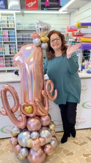 a woman standing next to a giant balloon