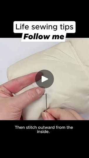 someone is sewing on the back of a pillow with their thumb pointed at it,