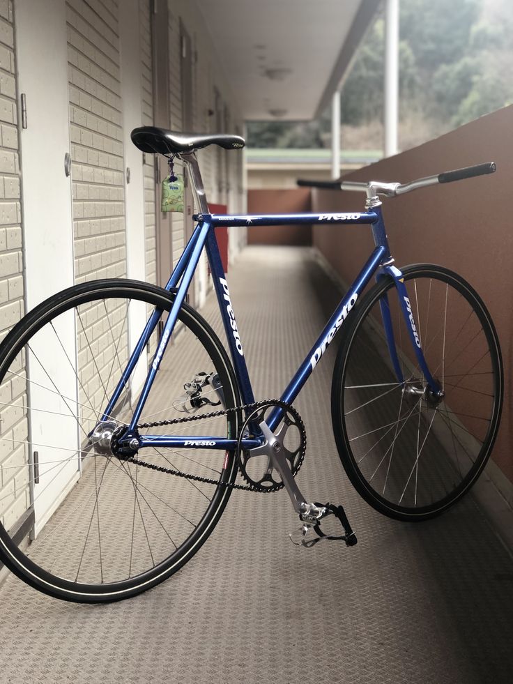 a blue bicycle parked on the side of a building