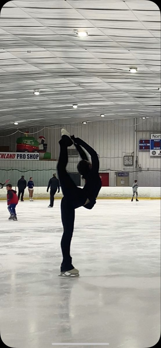 people skating on an ice rink with one doing a handstand