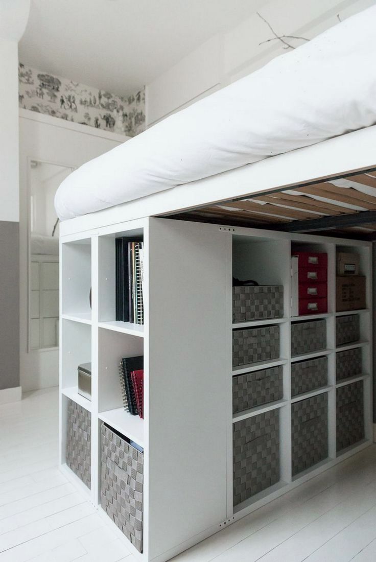 a loft bed with shelves underneath it and bookshelves on the bottom shelf below