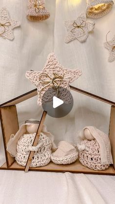 a display case with crocheted baby booties and other items in the shape of a house