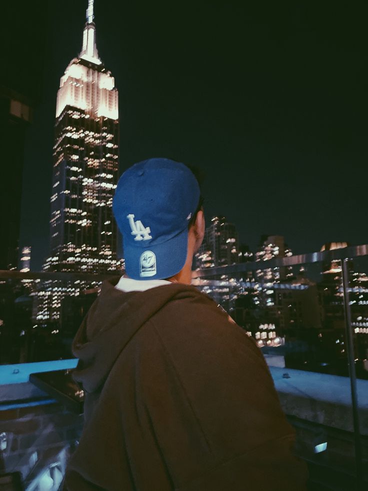 a man wearing a blue hat looking at the empire building