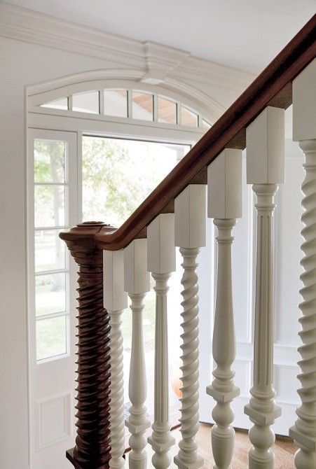 the stairs in this house are painted white and have wood balconies on them