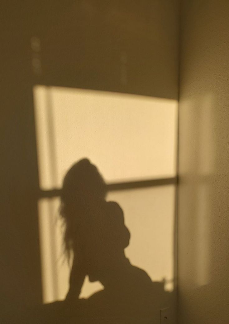 the shadow of a woman's head on a wall