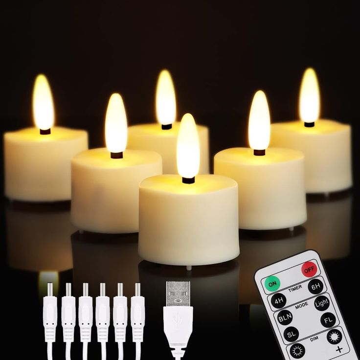 lit candles with remote controls on black surface