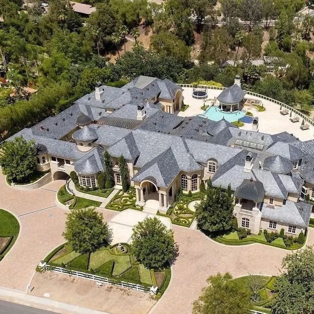 an aerial view of a large home surrounded by trees