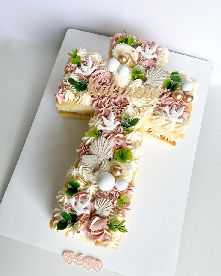 a cake shaped like the letter f on top of a white plate with flowers and seashells