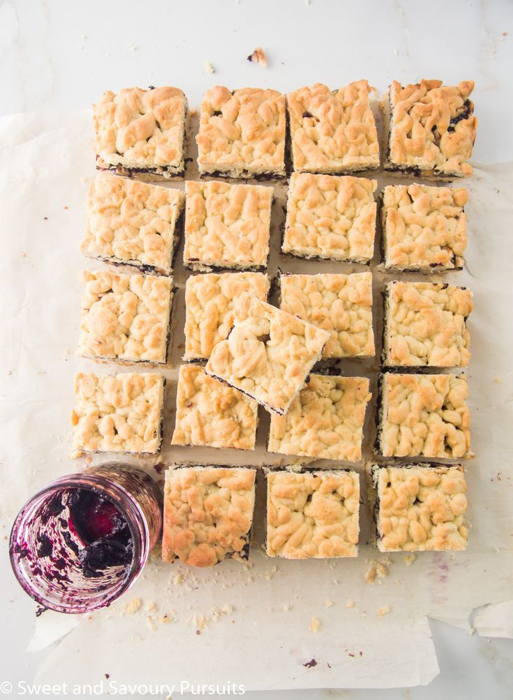 several squares of food next to a glass of wine