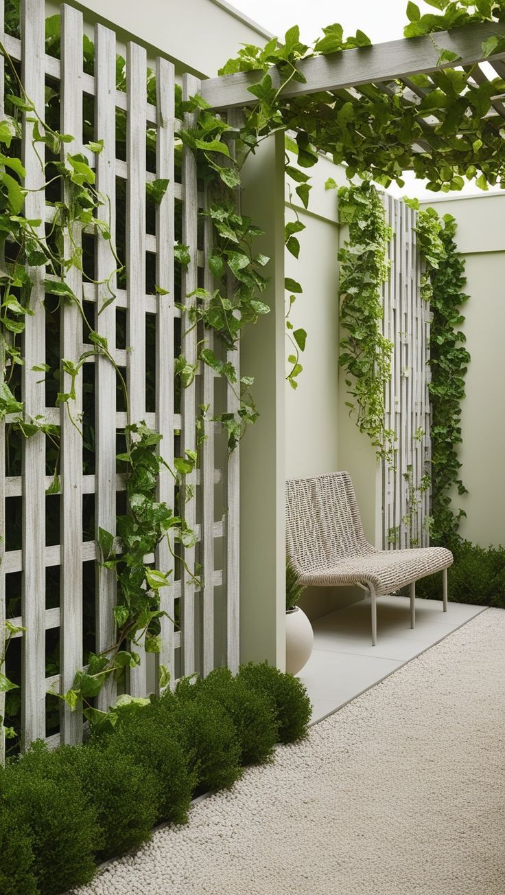 a white bench sitting under a pergolated trellis next to a wall covered in green plants