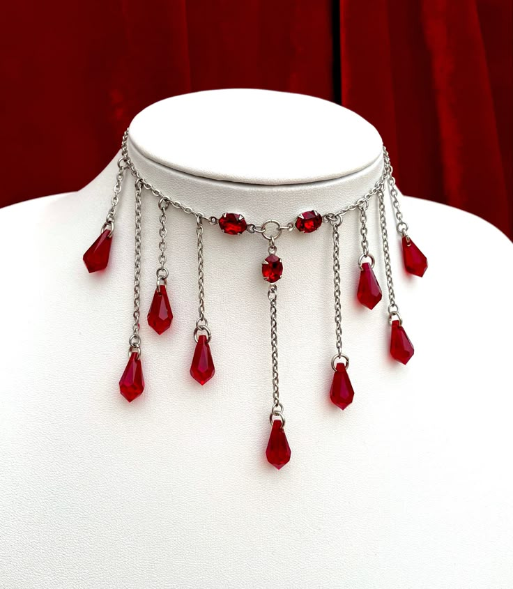 This bloody necklace features an array of glass faceted drops that hang from a stainless steel chain. The drops are also accompanied by gorgeous, high quality glass jewels which reflect light beautifully- perfect for blinding your prey. There are 2 chain length options available: Choker, the overall length is 16 inches including a 5 inch chain extender so that it can be worn between 11-16 inches. Standard Necklace, the overall length is 20 inches including a 5 inch chain extender so that it can be worn between 15-20 inches. Materials include; stainless steel, oxidised sterling silver plated brass and high quality glass. If you have any questions about this item, you are more than welcome to contact darklingbeloved@gmail.com Necklace Blood, Blood Necklace, Droplet Necklace, Vampire Necklace, Red Choker, Blood Drop, Goth Choker, Goth Necklace, Vampire Goth