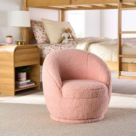 a pink chair sitting in front of a bunk bed with a white rug on the floor