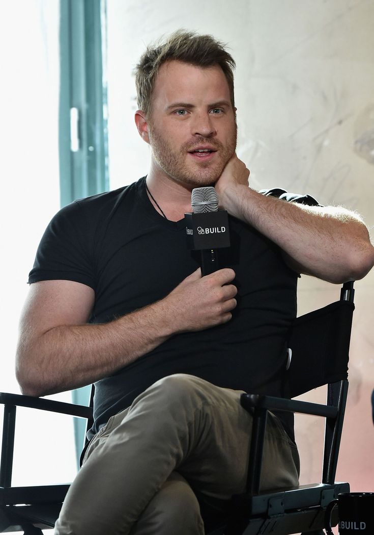 a man sitting in a chair holding a microphone