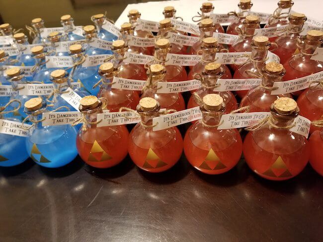 many small bottles with labels on them are sitting on a table next to each other