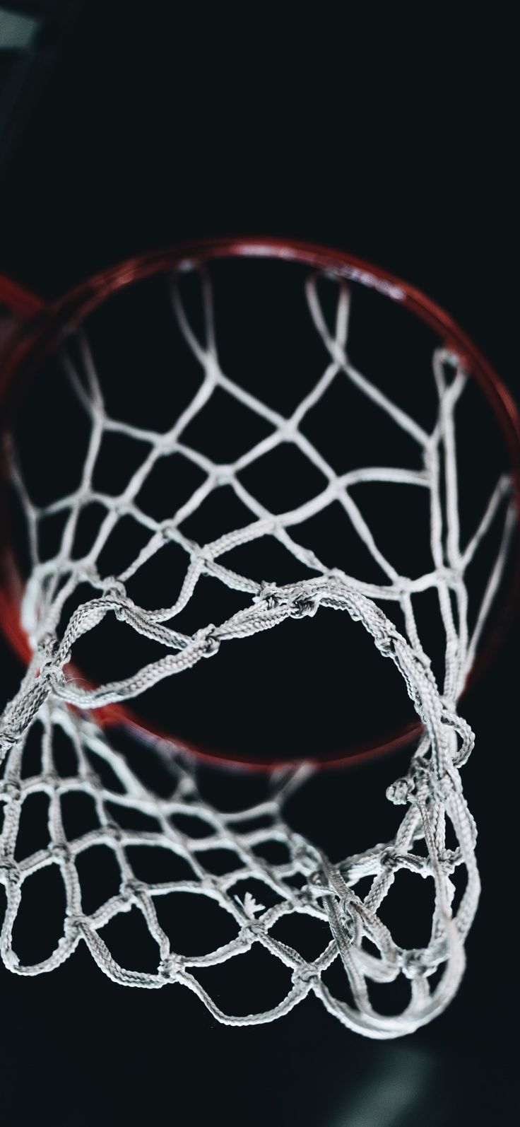 a basketball hoop with the net in front of it on a black background, taken from above