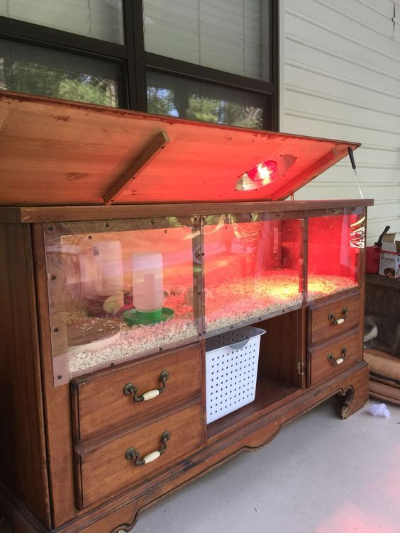 an old wooden cabinet with fish tanks on it's sides and drawers in front