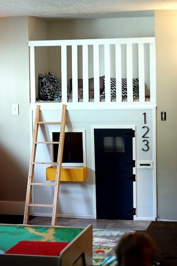 a child's bedroom with bunk bed and stairs to the top floor, next to a play area