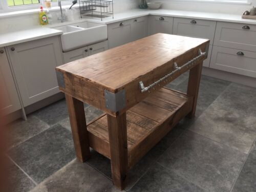 a wooden table sitting in the middle of a kitchen