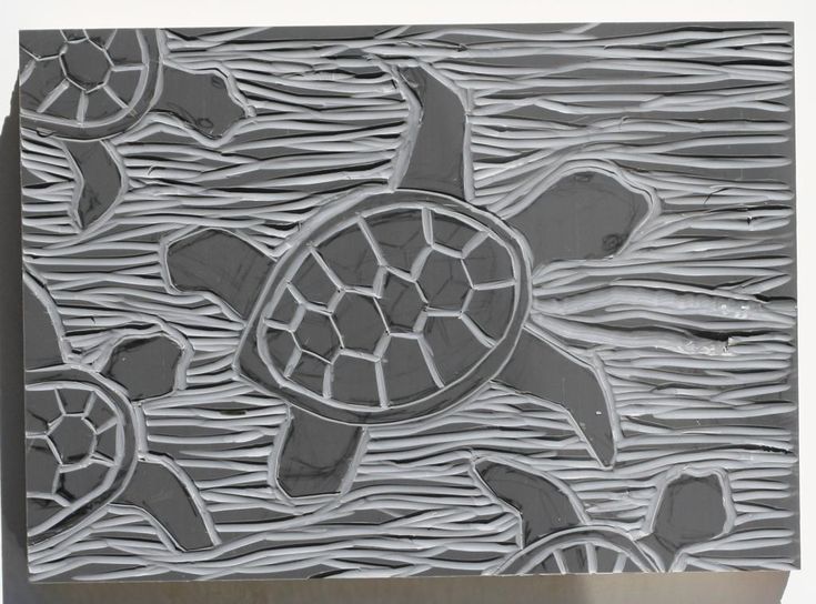 an intricately designed tile with sea turtles and waves in grey tones on a white background