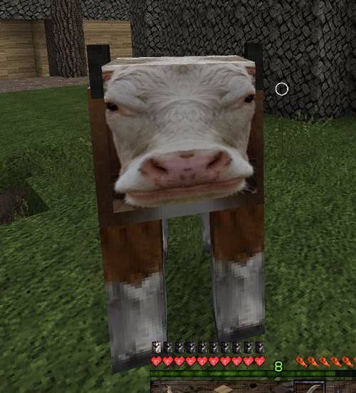 a cow is standing in the grass with its head sticking out of it's mouth