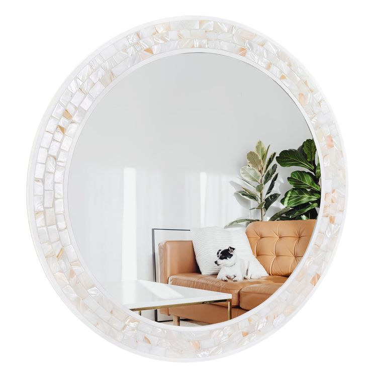 a living room with a couch and a round mirror