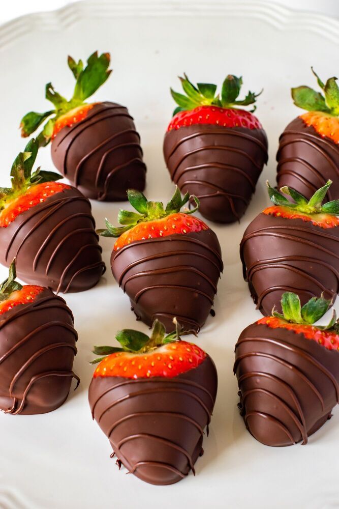 chocolate covered strawberries are arranged on a white plate