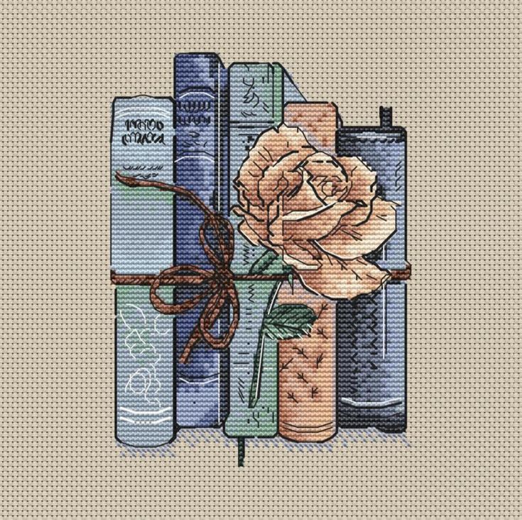 a cross stitch pattern with books and a rose on the top, tied in brown ribbon