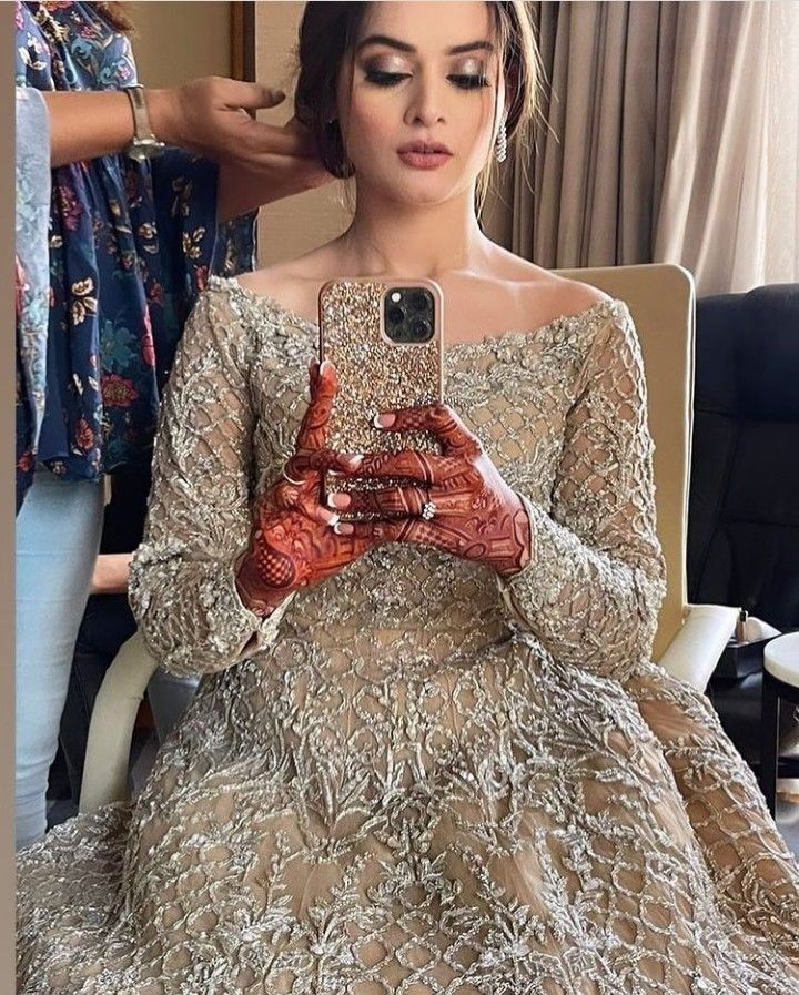 a woman is taking a selfie with her cell phone while wearing a wedding dress