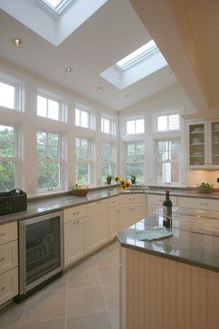 a large kitchen with lots of counter space and windows on the ceiling, along with an oven